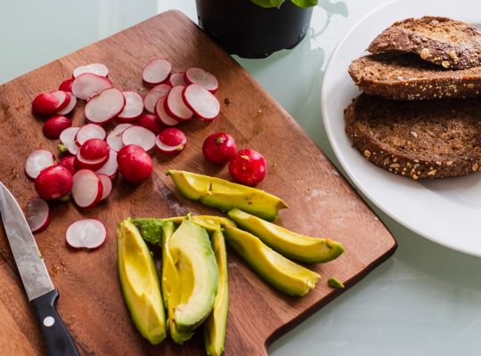 banana fruit and bread on brown wooden chopping board