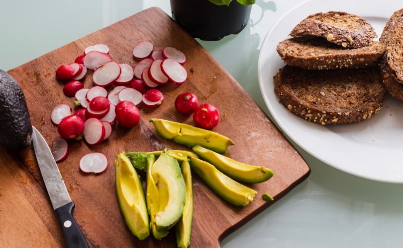 banana fruit and bread on brown wooden chopping board